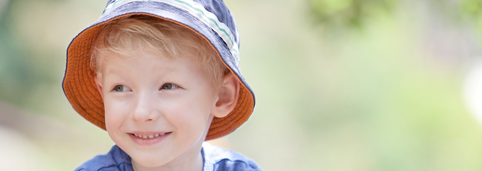 Smiling young child wearing a sun hat